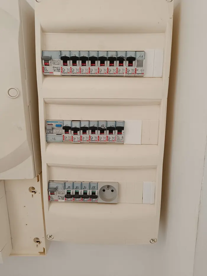 Tableau électrique à trois rangées de disjoncteurs, capot posé, avec prise intégrée